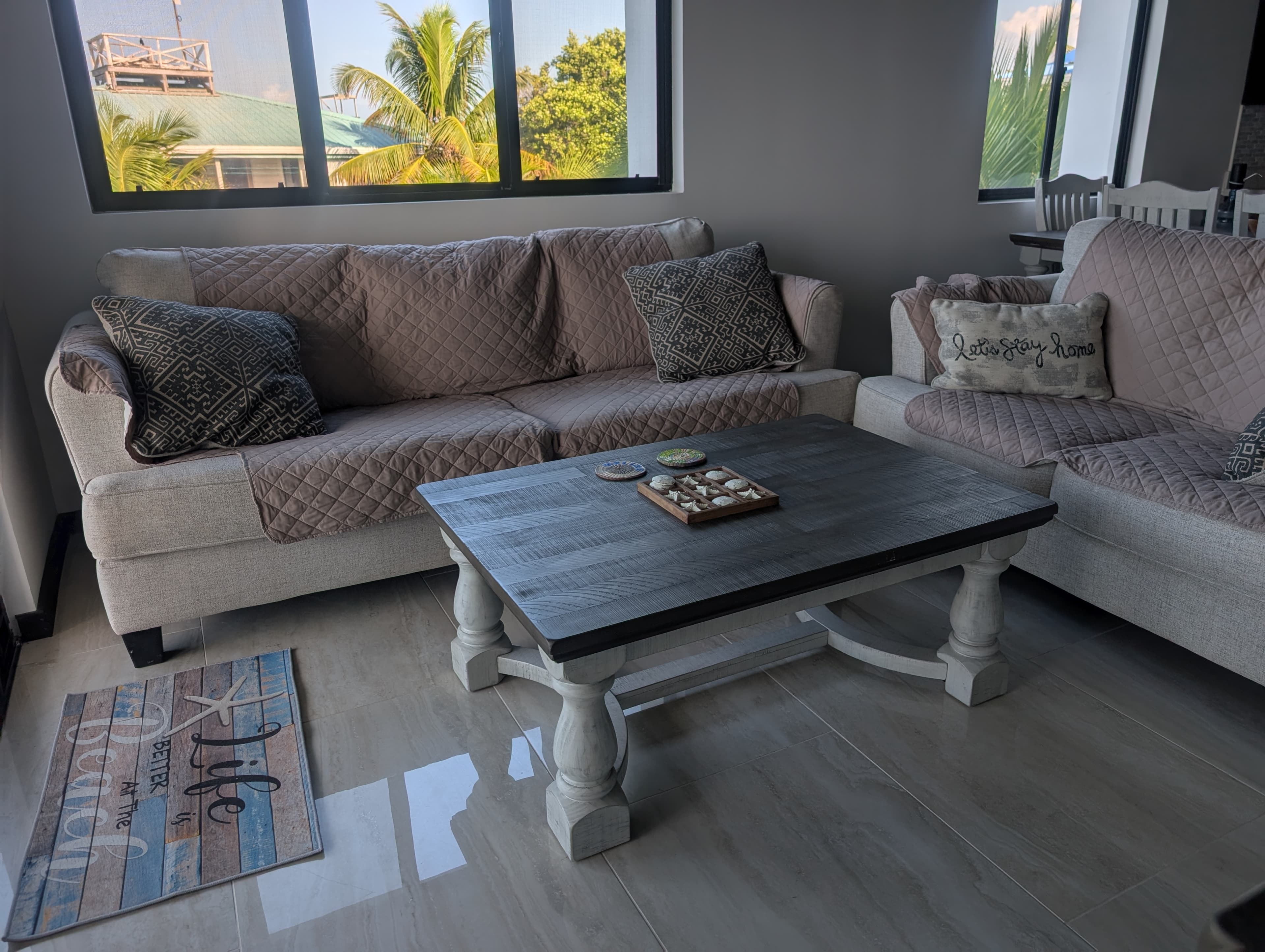 living space with 2 couches and coffee table tan with expresso woodwork white walls