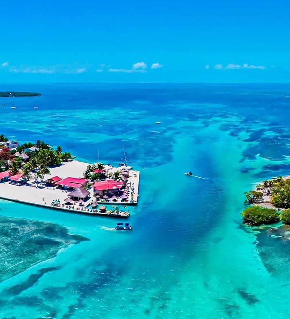 Aerial view of a tropical coastline with turquoise waters and a small beach resort.