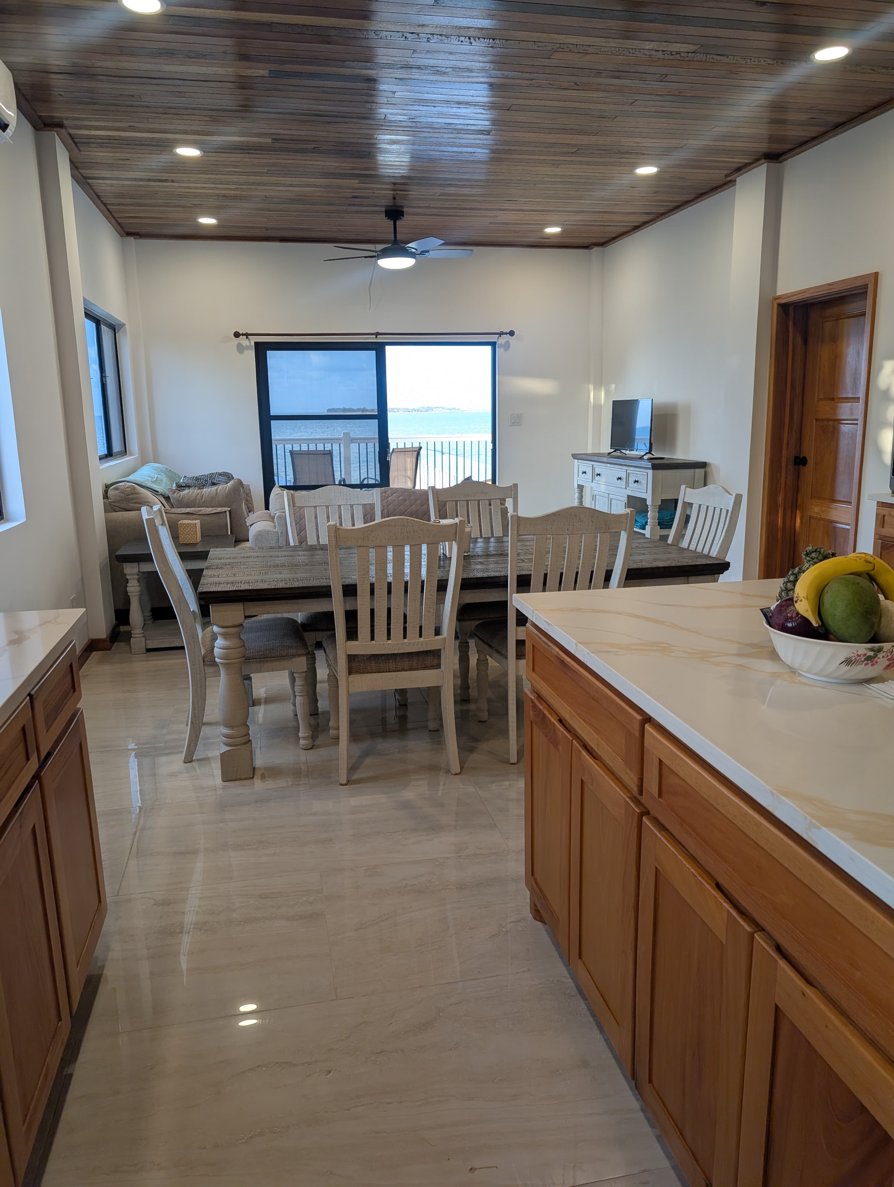 Bright dining area with a wooden table, chairs, and a view through sliding glass doors.