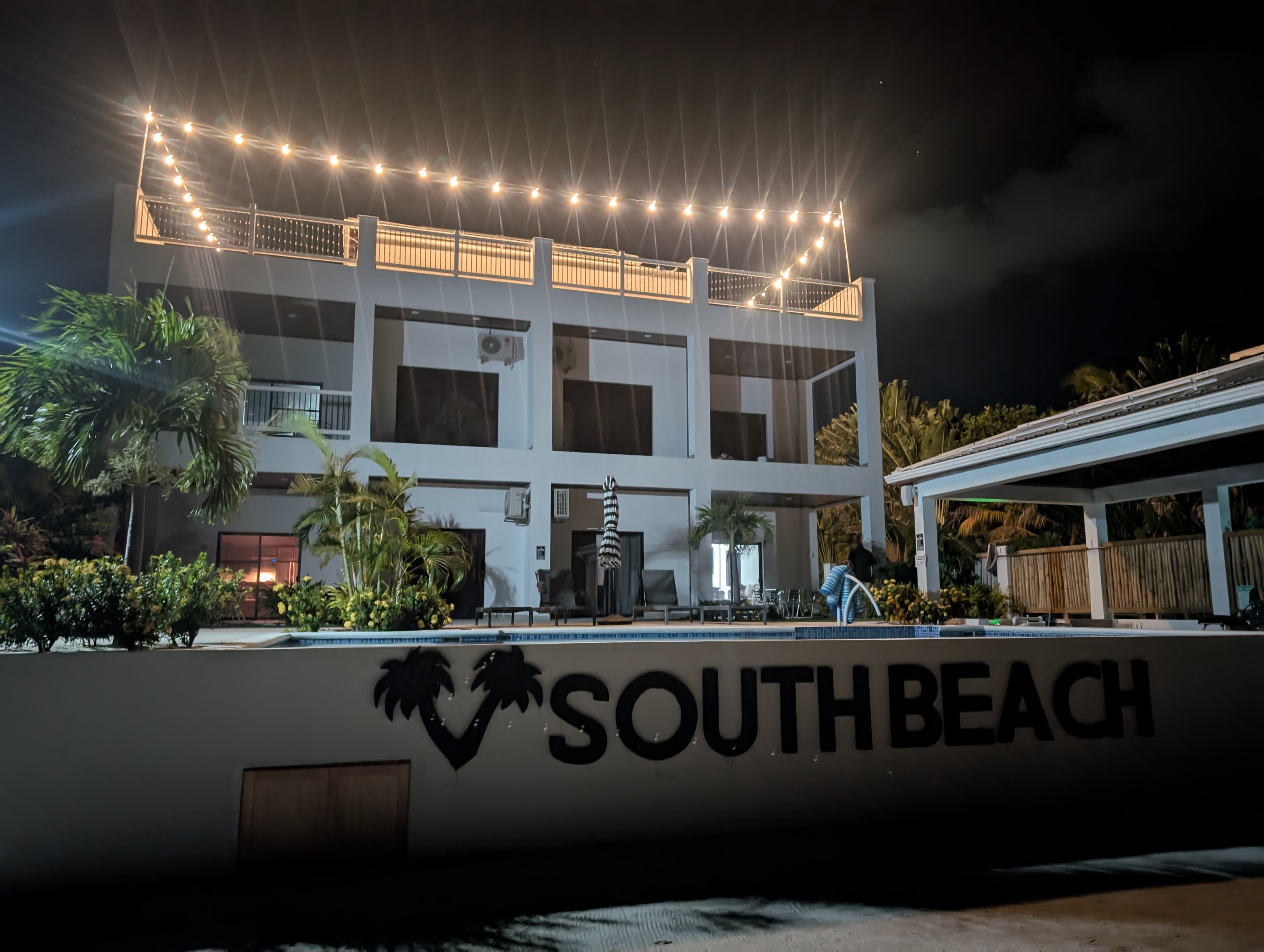A modern building with lights at night, featuring a sign that says "SOUTH BEACH."